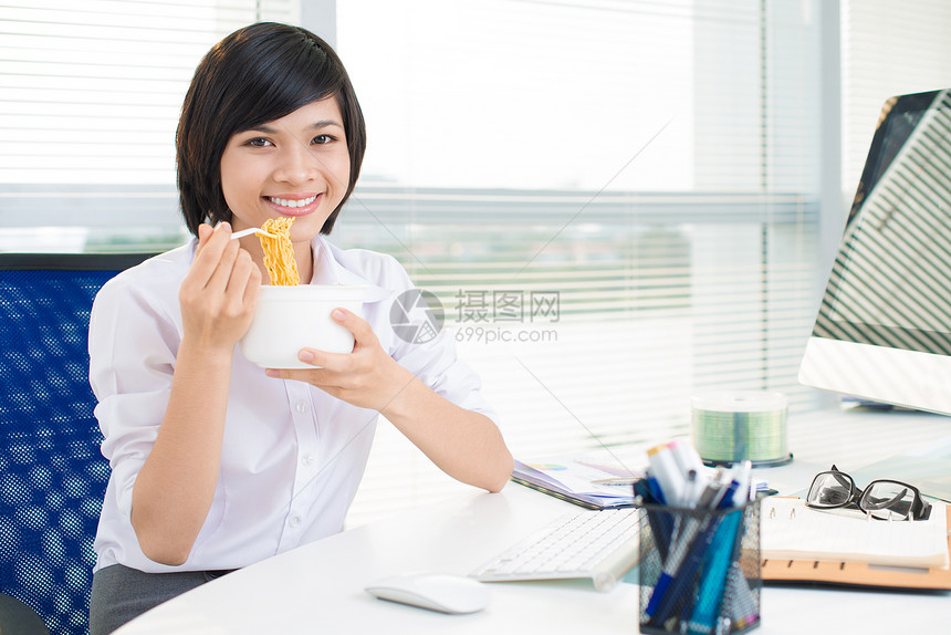 享受她的办公室用餐的迷人的女实业家图片