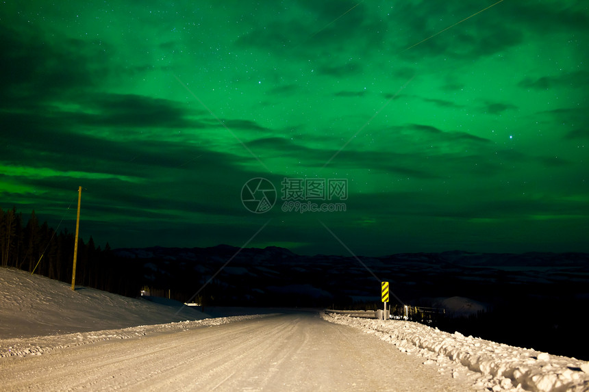 北极光或北极光或极光照亮多雪的冬季道路图片