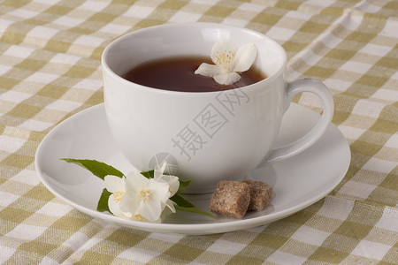 CupofJasmine茶和棕色糖方块在橄图片