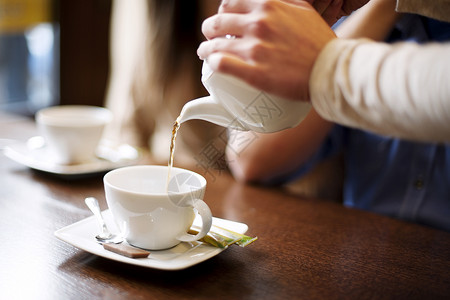 女服务员倒杯咖啡或茶图片