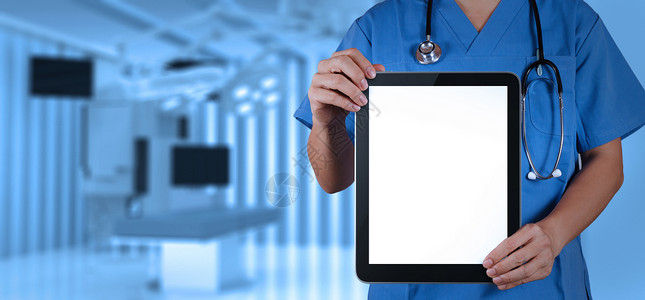 医生在带手术室的平板电脑上工作图片