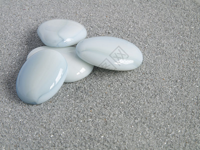 灰色沙滩上的蓝色圆形石头图片