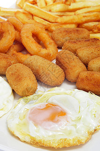 西班牙组合拼盘与煎鸡蛋炸丸子鱿鱼和炸薯条的特写镜头图片