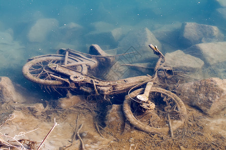 扔在河岸上的旧轻便摩托车的摄影图片