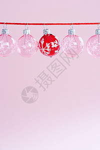 粉红色和红色的小圆球圣诞树装饰品挂在一条红色的绳子上图片