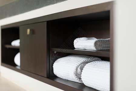用木制架建的墙壁浴室内一整堆白色软毛巾用干净的折叠纺织品闭图片