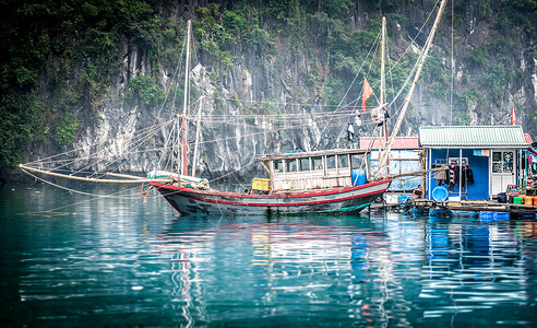越南下龙湾波光粼的蓝色海水中漂浮的渔船和房屋落基山风景图片
