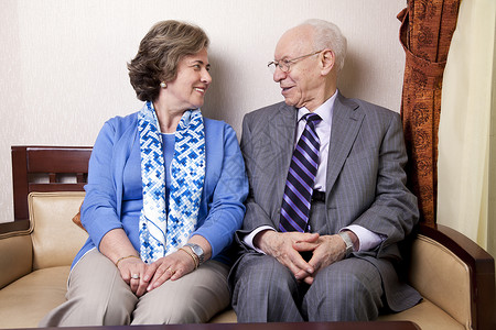 一位坐在沙发上的高官夫妇用爱和欢乐的心情看着对方图片