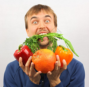 人吃绿色的东西手里拿着新鲜的蔬菜和水果图片