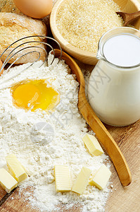 牛奶面粉黄油鸡蛋糖和木勺的配料图片