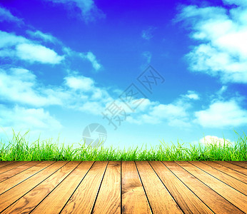 新鲜的春天绿草蓝天和木地板图片