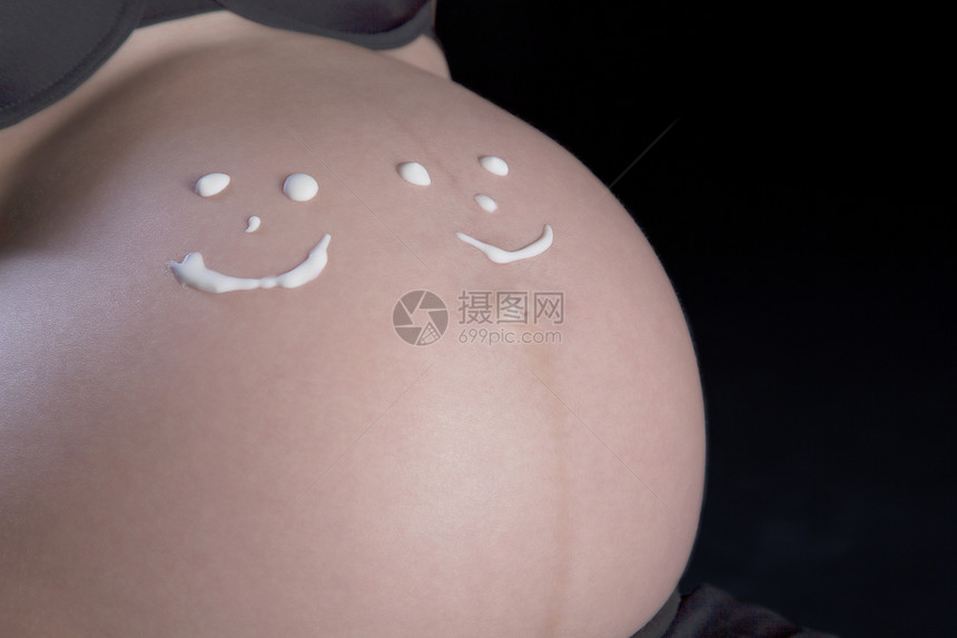 有两个笑脸的孕妇在大肚子上画着两张笑脸图片