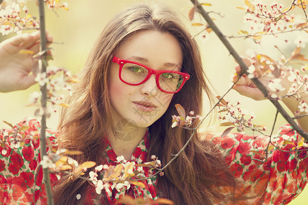 戴眼镜的少女靠近开花树图片