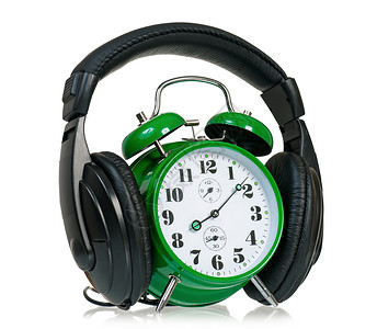 带耳机的绿色闹钟在白图片
