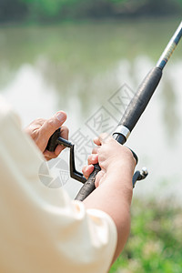 拿着钓鱼竿的男手的特写镜头图片