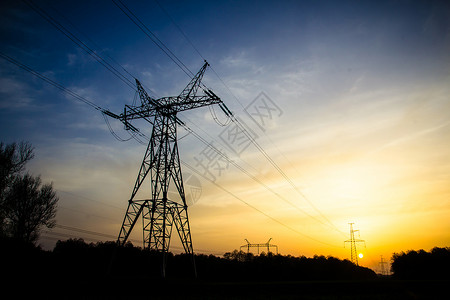 夕阳背景下的高压输电塔剪影图片