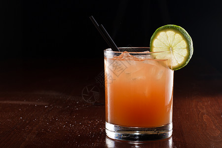 热带果汁鸡尾酒在黑暗的酒吧里供应被图片