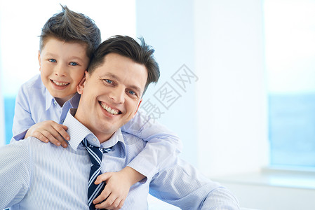 喜悦的男孩抱着他爸和两个看图片