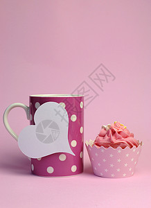 Polka点咖啡杯粉红色纸杯蛋糕和白色的心形礼物标签图片