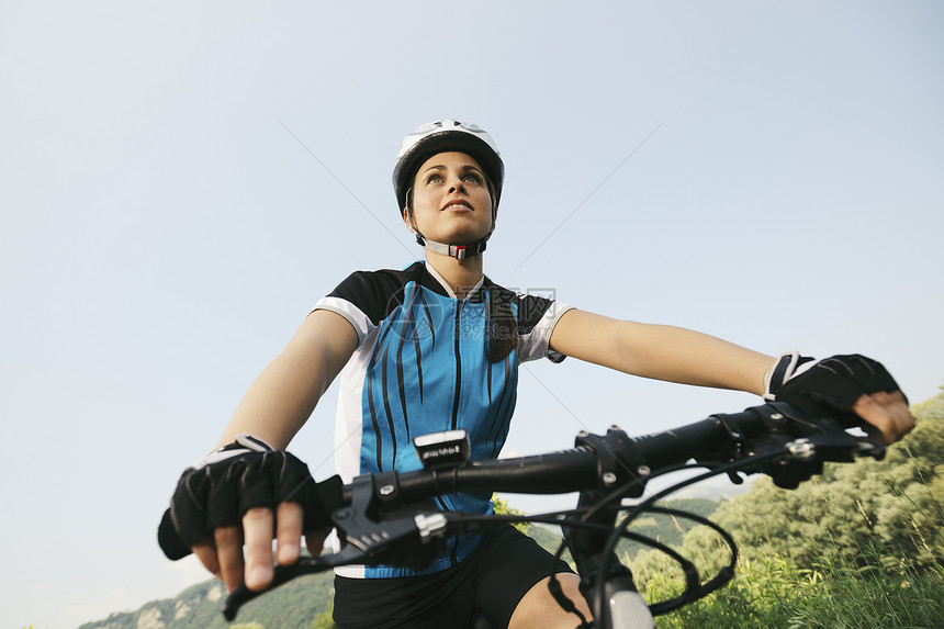 年轻女子在山地自行车和公园骑自行车培训复制空间图片