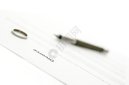 离婚文件上的结婚戒指和墨水笔离婚概念图片