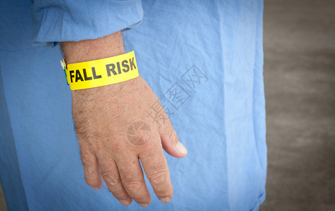 一位身穿蓝色长袍戴着跌倒风险手镯的病人图片