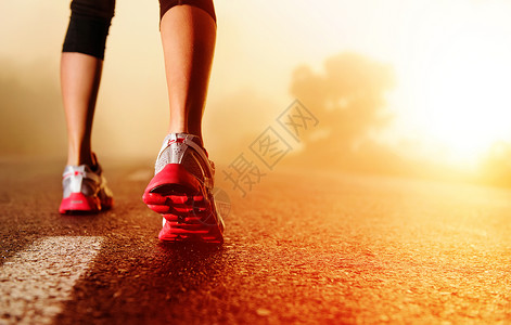 妇女健身日出慢跑概念在路边紧贴鞋背景图片