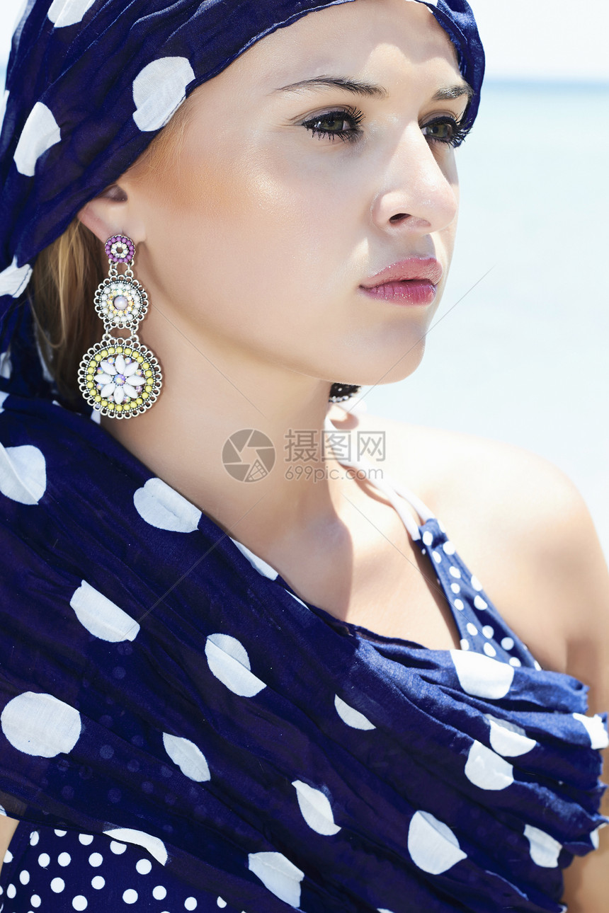 沙滩上披着蓝色披肩的美女肖像图片