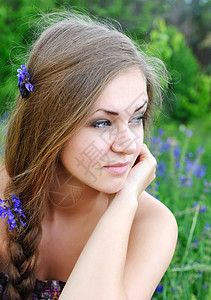 一位美丽的年轻女子的肖像在紫花朵图片