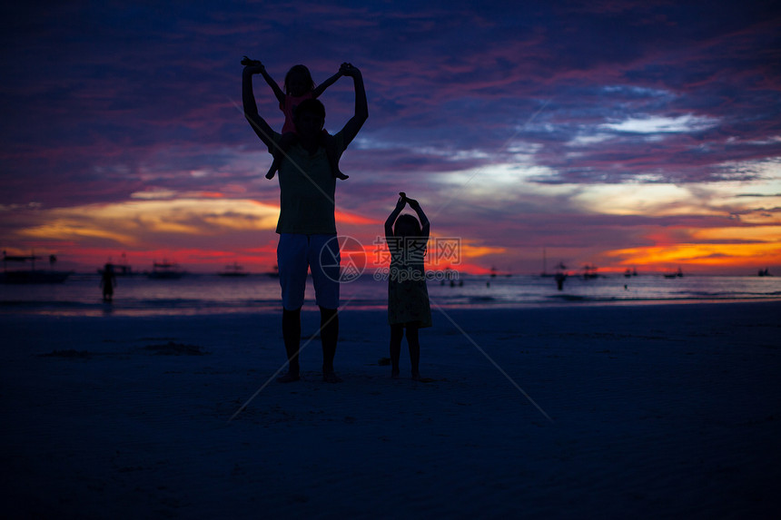 长滩岛海滩日落时的爸和女儿剪影图片