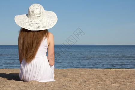 美丽的女人坐在沙滩图片