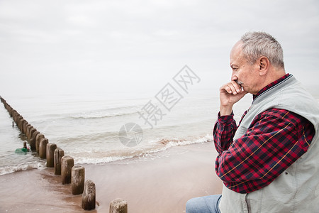 大雾天站在沙滩上体贴的老人图片