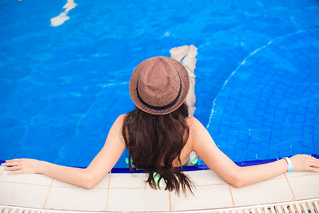 在泳池里戴帽子的年轻女图片