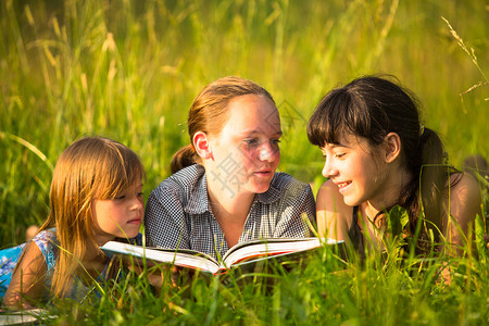 三个小姊妹一起读自然环境的书在自然图片
