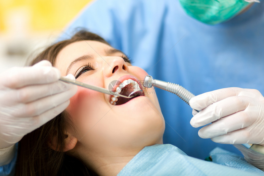 治疗一名女患者的牙医图片
