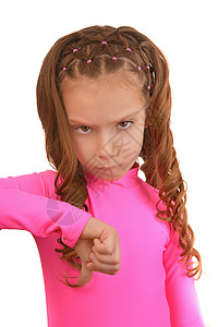 穿粉红色裙子的很严酷的小姑娘低着大拇指孤立图片