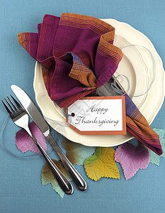 现代感恩节餐桌位设置在水蓝色桌布上图片