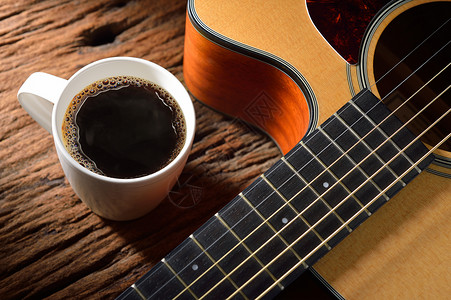 木桌上的咖啡杯和吉他图片