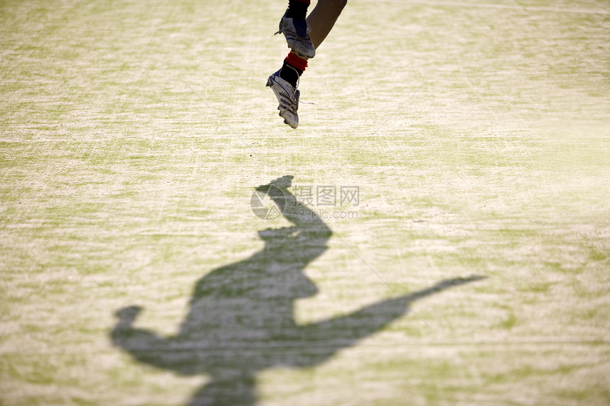 足球运动员正在跳跃以获得橄榄球图片