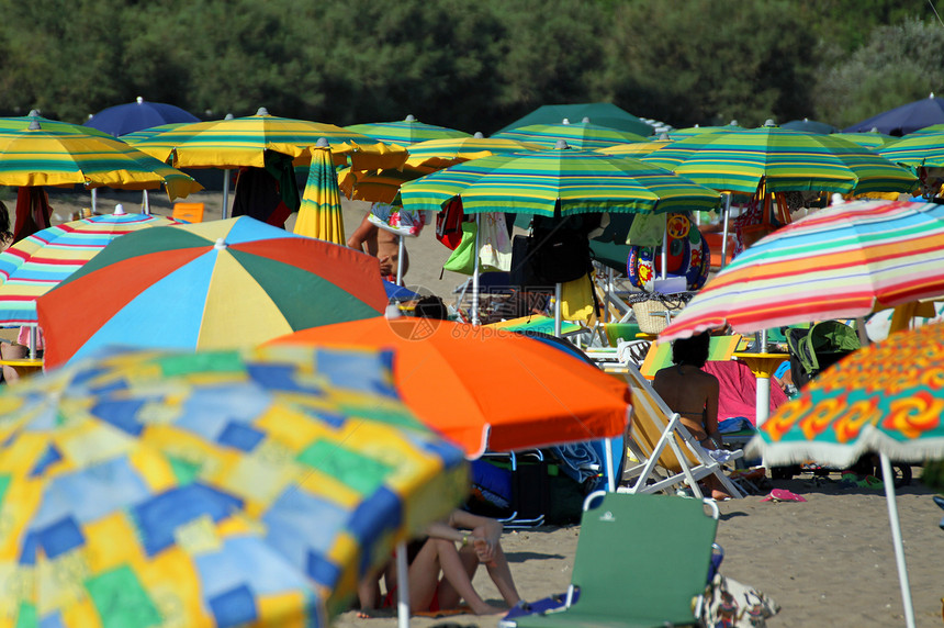 许多雨伞堆积在拥挤的海滩上图片