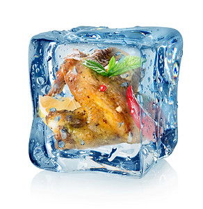鸡翼在冰雪的立方体中孤立图片