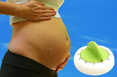 孕期妇在分娩时与计时器背景图片