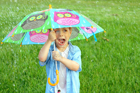 一个小孩在雨中拿着多彩的图片