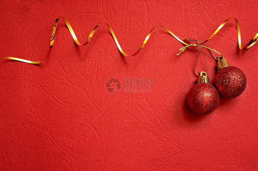 与圣诞球和飘带的红色背景图片