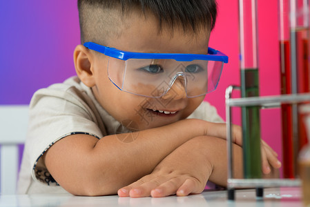 一个小男孩的近视图像看着化学物质并有兴趣在实验图片