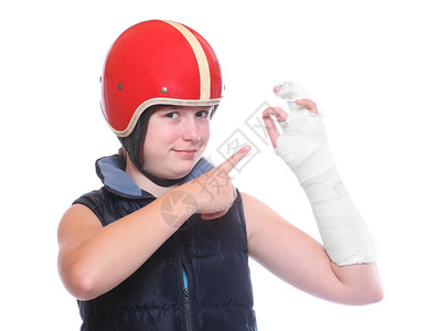 戴着防护头盔的少年手臂骨折保险隐喻图片