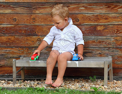 小男孩在乡村长椅上玩耍图片