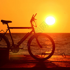 海边夕阳下的自行车剪影图片