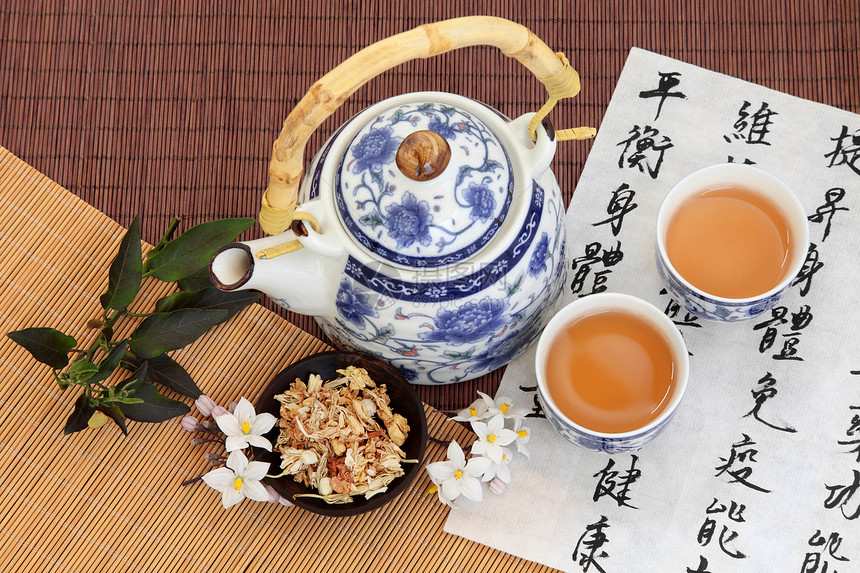 茉莉花茶用中草药用普通话书法在宣纸和茶壶上翻译描述了增加身体维持身心健康和平衡能量的能图片