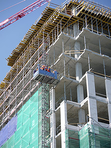 一群建筑工人使用外部电梯登上多层建筑开图片
